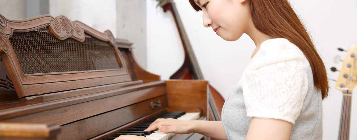 女性が楽しそうにピアノを弾く横顔